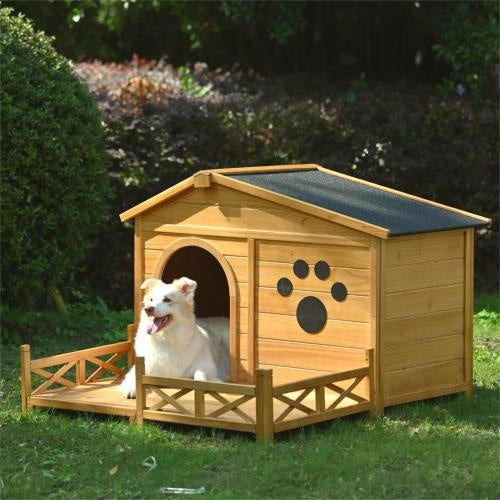 Wooden dog house with a white dog inside, surrounded by greenery