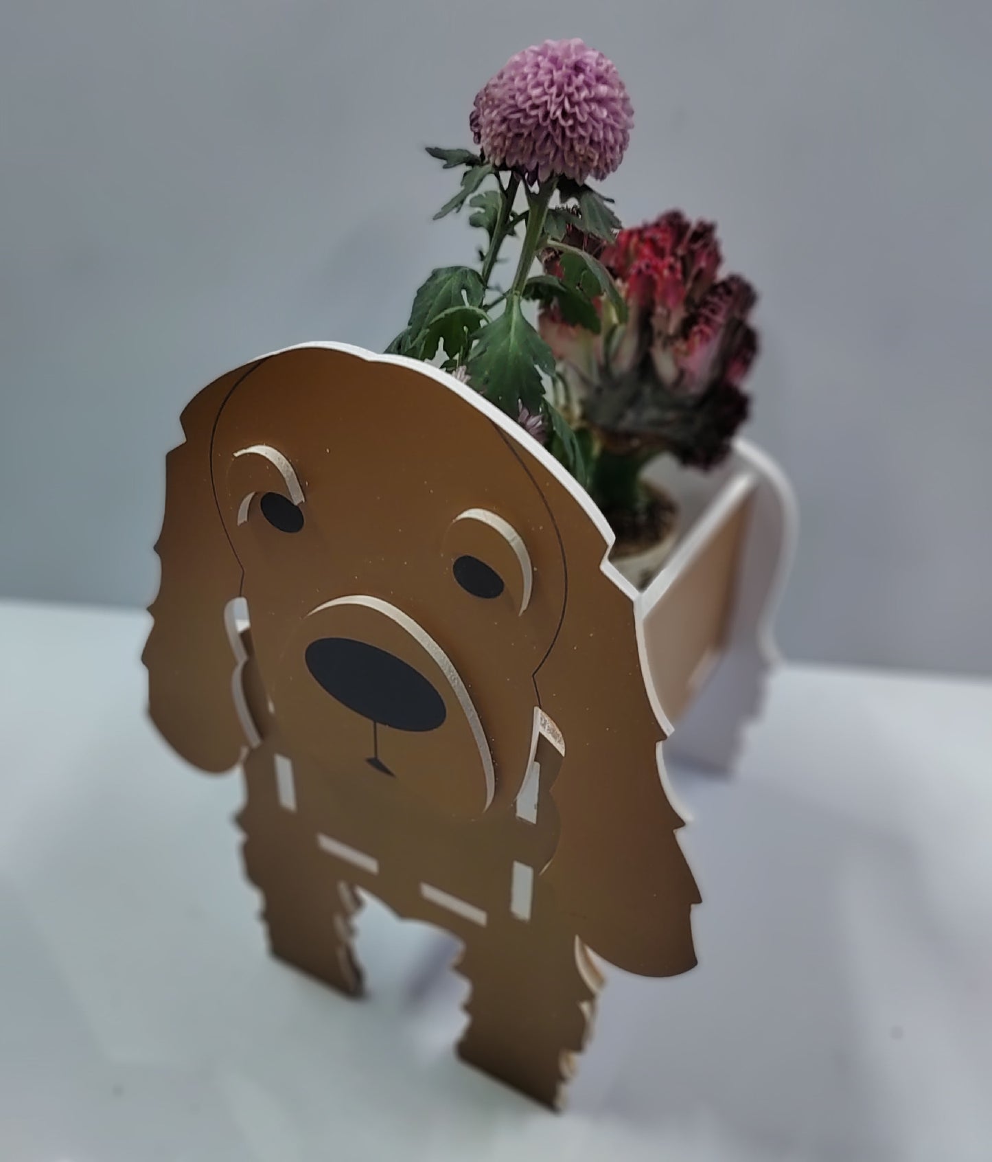 Dog-shaped planter with flowers on a white background