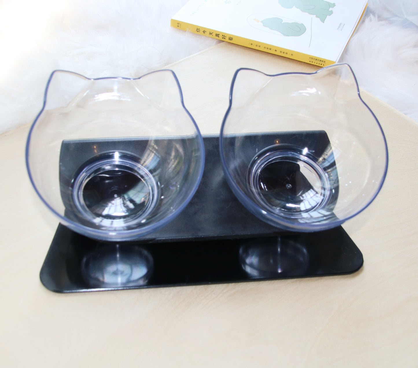 Cat-shaped double bowl feeder on a white surface