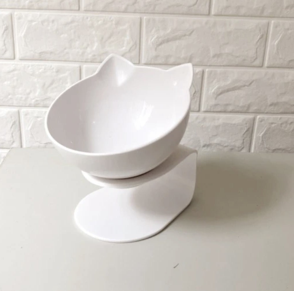 White ceramic pet bowl on a white surface with a white tiled wall background
