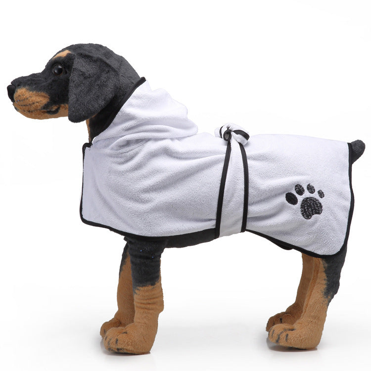 Dog wearing a white bathrobe with black trim and paw print on a white background