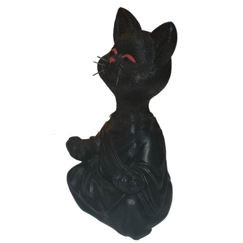 Black cat figurine with red eyes on a white background