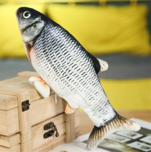Fish-shaped plush toy on a wooden box with a blurred background
