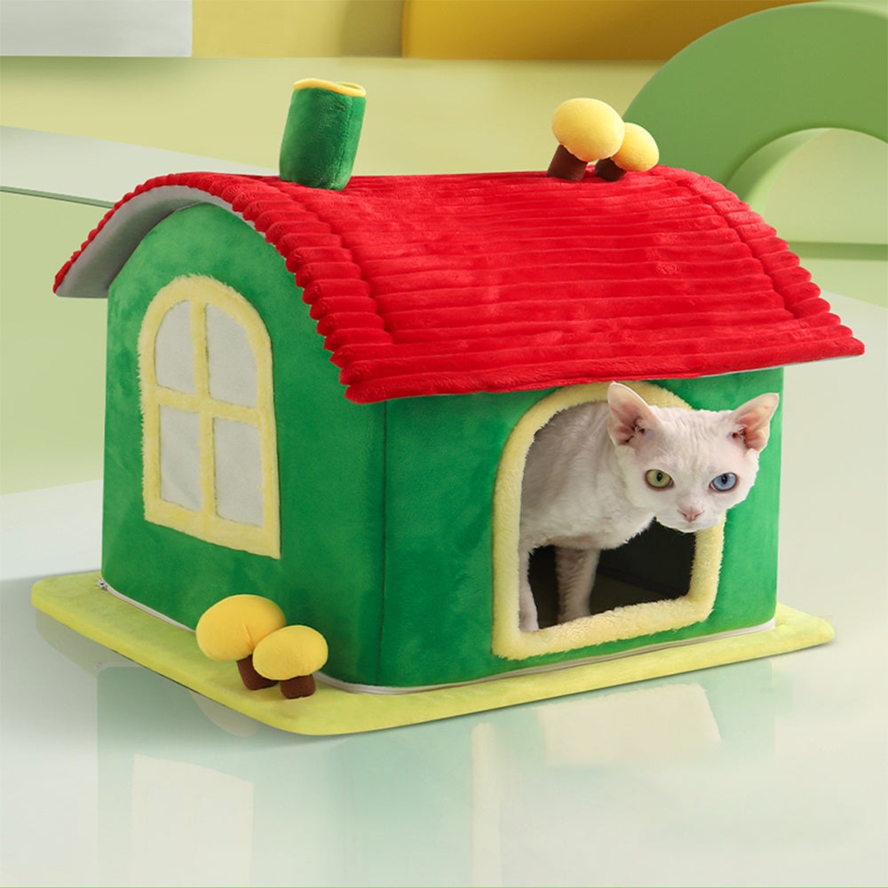 Cat house shaped like a green house with a red roof, featuring a cat peeking out.