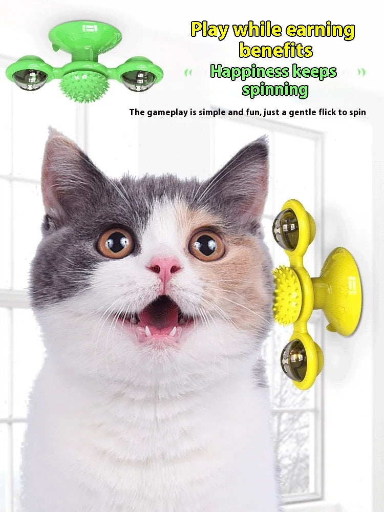 Cat interacting with a green and yellow fidget spinner toy