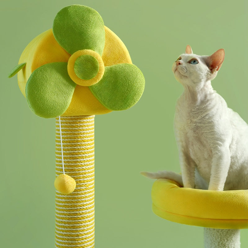 Cat sitting on a yellow and green cat tree against a green background