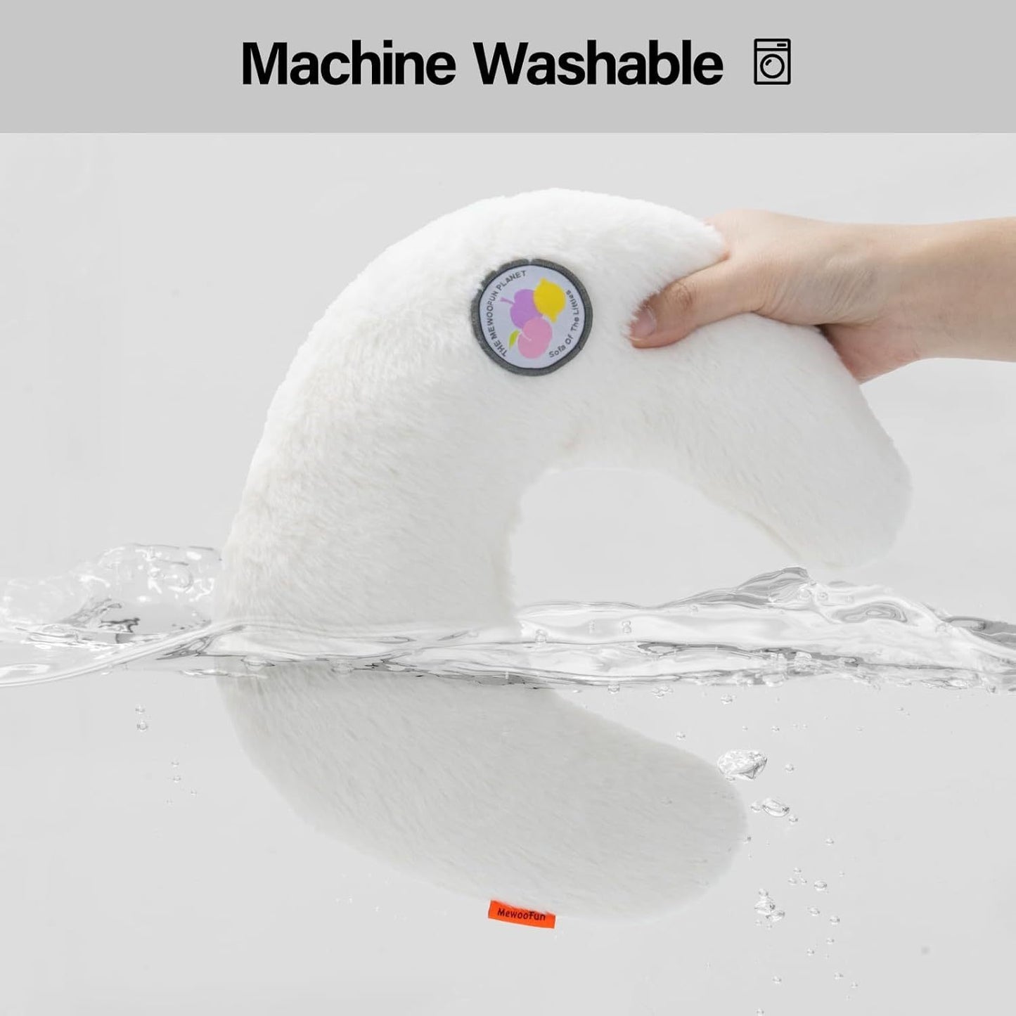 White plush toy with a hand holding it above water, labeled 'Machine Washable'.