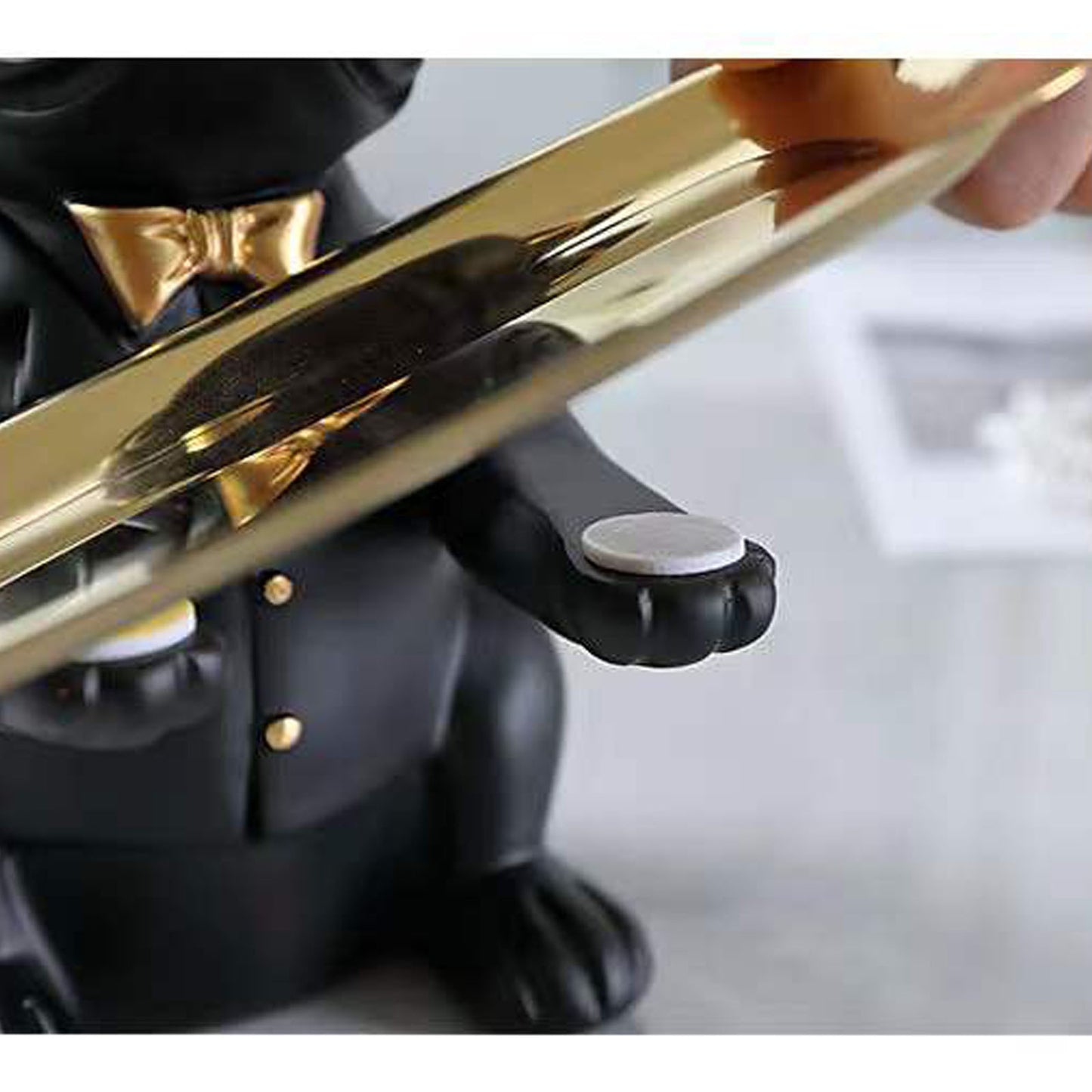 Close-up of a person holding a gold and black figurine of a dog.
