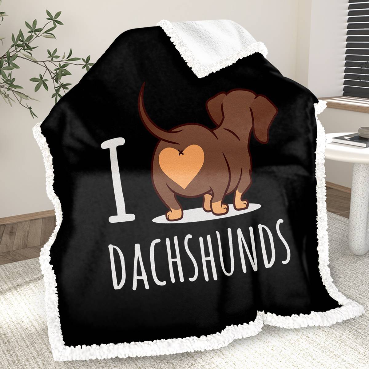 Black blanket with a dachshund design and 'I love dachshunds' text on a carpeted floor.