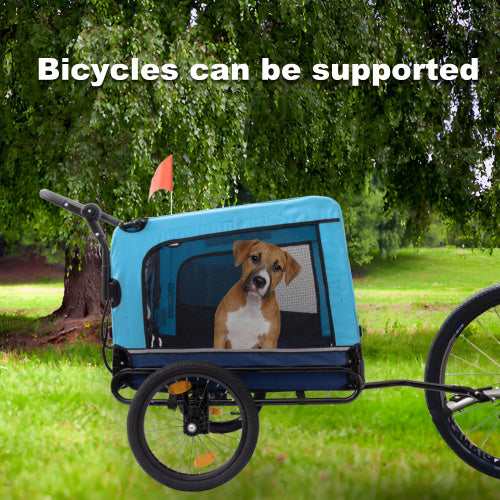 Blue bicycle pet trailer with a dog inside, parked on grass with trees in the background.