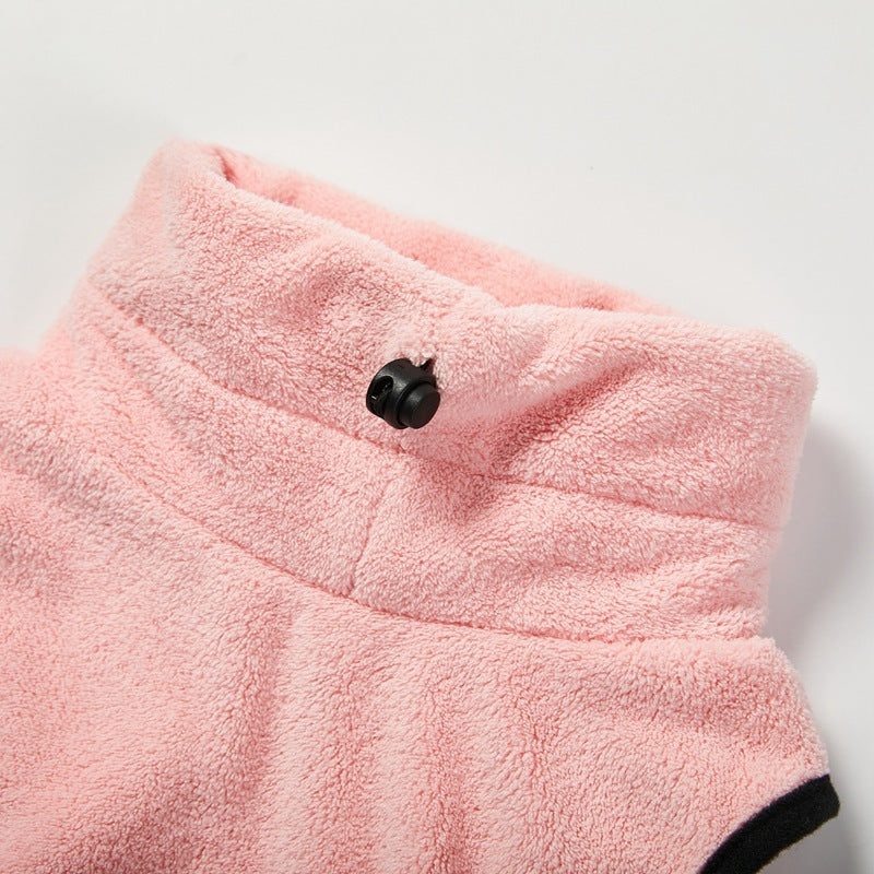 Close-up of a pink dog microfiber bath towel with a black button on a light gray background.
