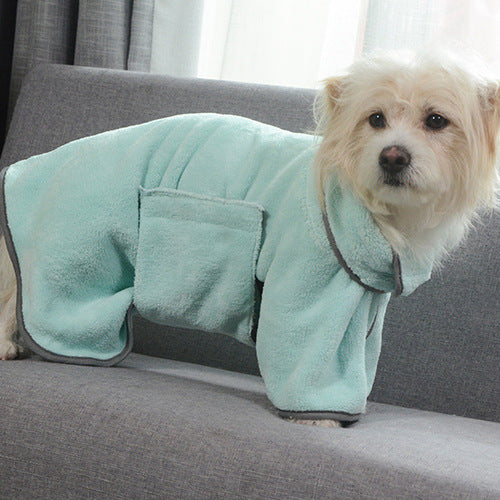 Dog wearing a light blue robe on a gray couch