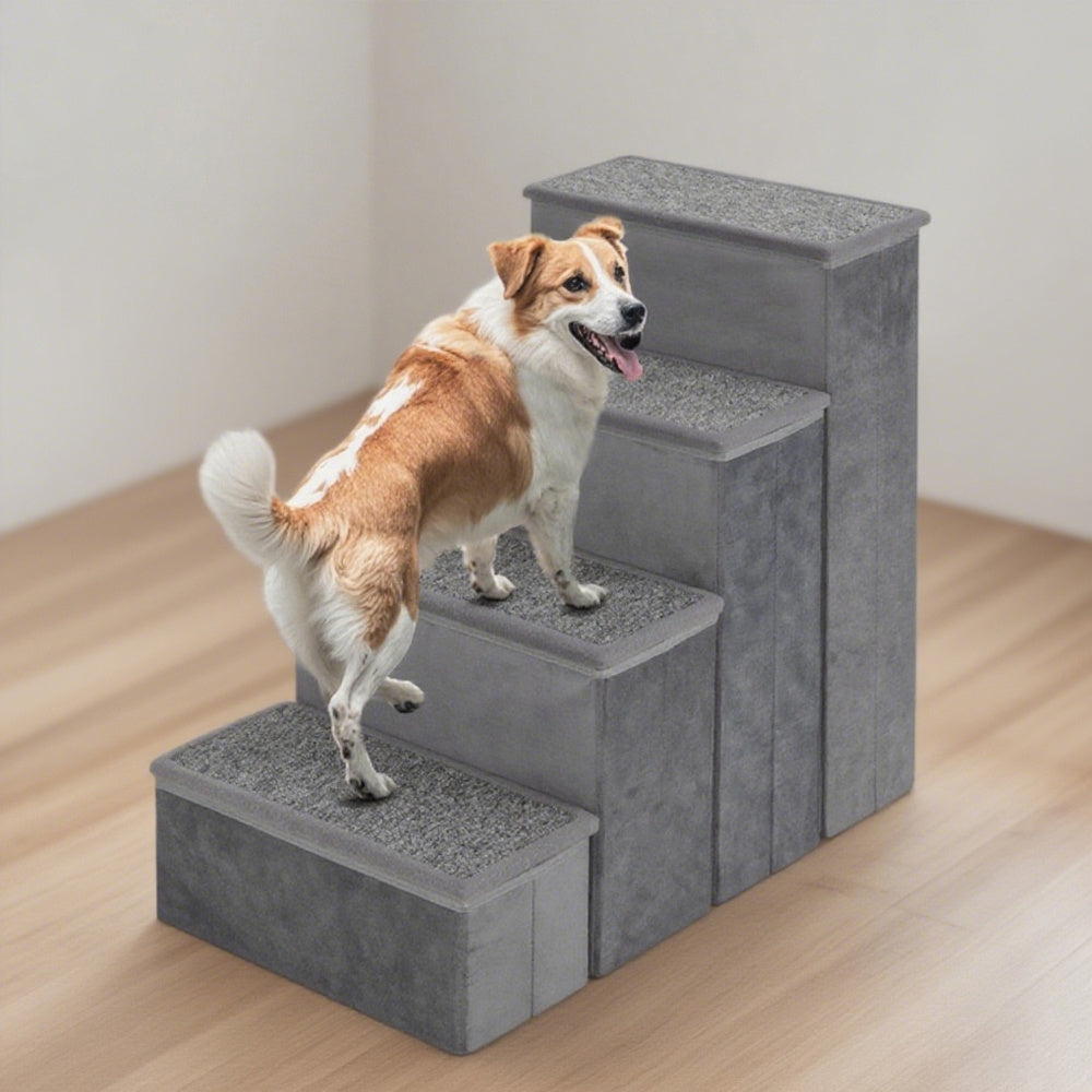 Dog using a set of gray pet stairs on a wooden floor.