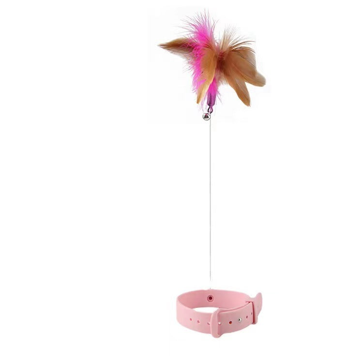 Pink cat toy with feathers and a bell on a white background