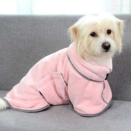Dog wearing a pink fleece coat sitting on a gray couch.