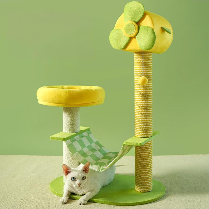 Green and yellow cat tree with a cat sitting on a green platform against a light green background