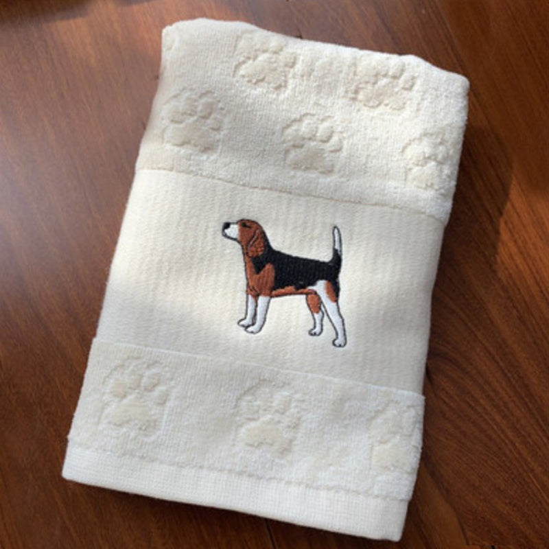 Folded towel with a dog illustration on a wooden surface