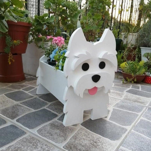 White dog-shaped planter with a pink tongue on a stone patio surrounded by plants.
