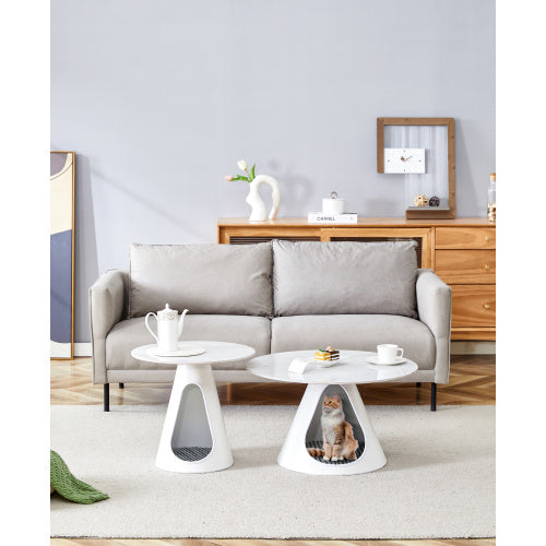 Living room with a gray sofa, small round white table, and a cat bed on a white table.