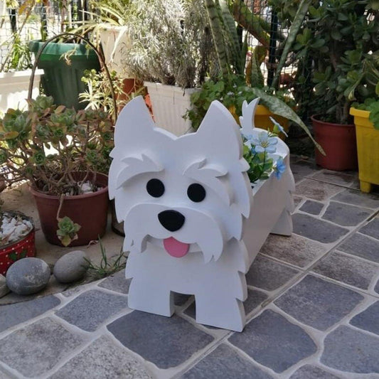 White dog-shaped planter with black eyes and a pink tongue, surrounded by potted plants on a stone patio.