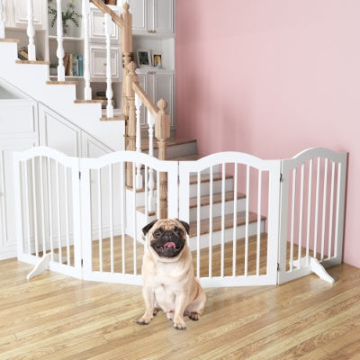 Pug standing behind a white pet gate in a home setting with pink walls and wooden floors.