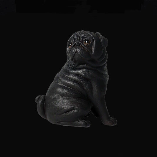 Black pug figurine on a black background