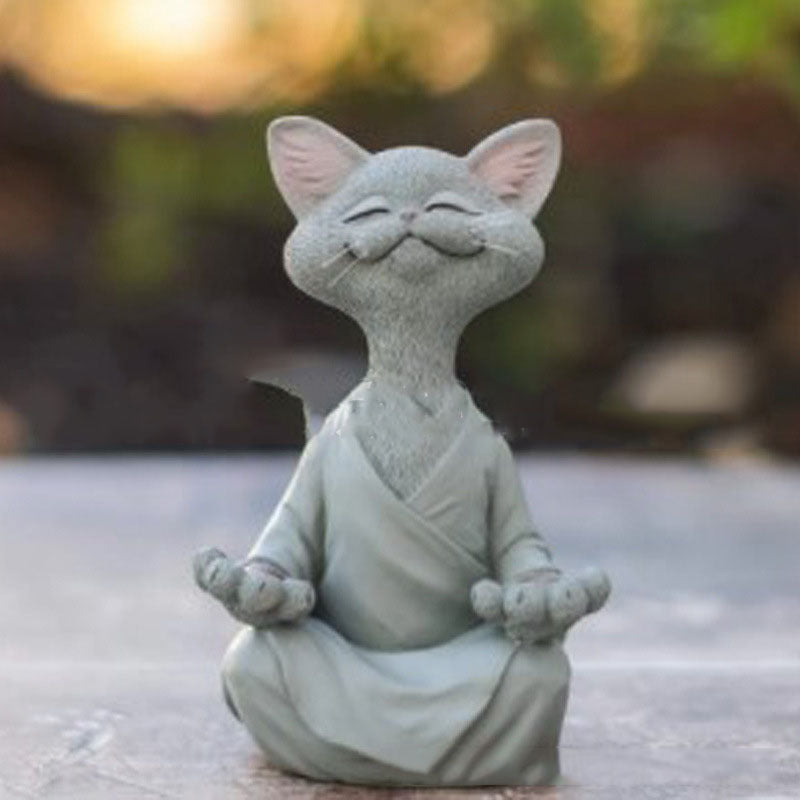 Stone cat figurine meditating with a blurred natural background