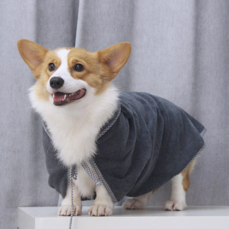 Dog wearing a gray bathrobe against a gray curtain background