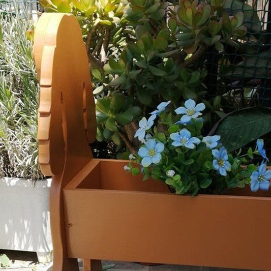 Wooden planter box with blue flowers and green plants in a garden setting