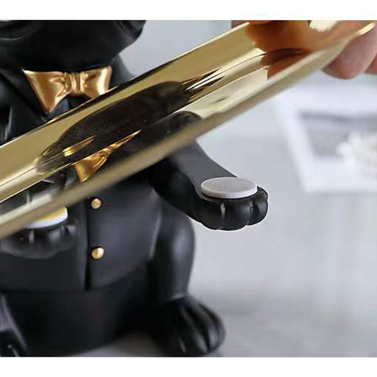 Close-up of a person holding a gold and black figurine of a dog.