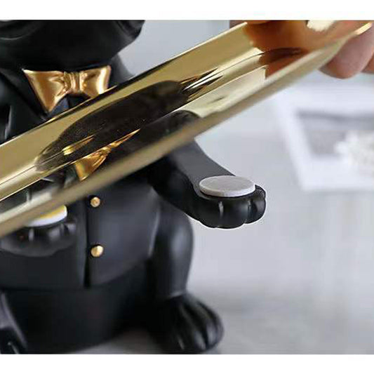 Close-up of a person holding a gold and black figurine of a dog.