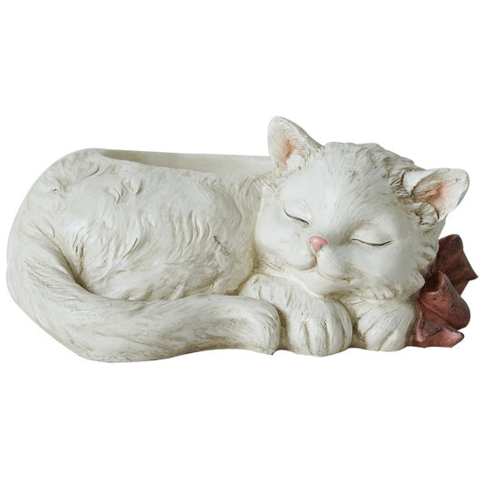 White cat figurine sleeping with a red flower on a white background