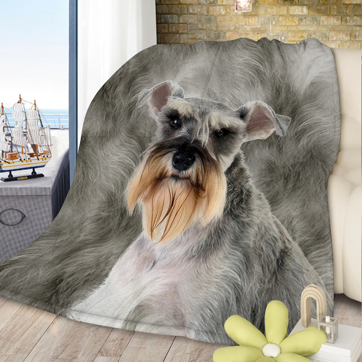 Fluffy gray dog blanket draped over a chair with a decorative flower and ship model in the background.