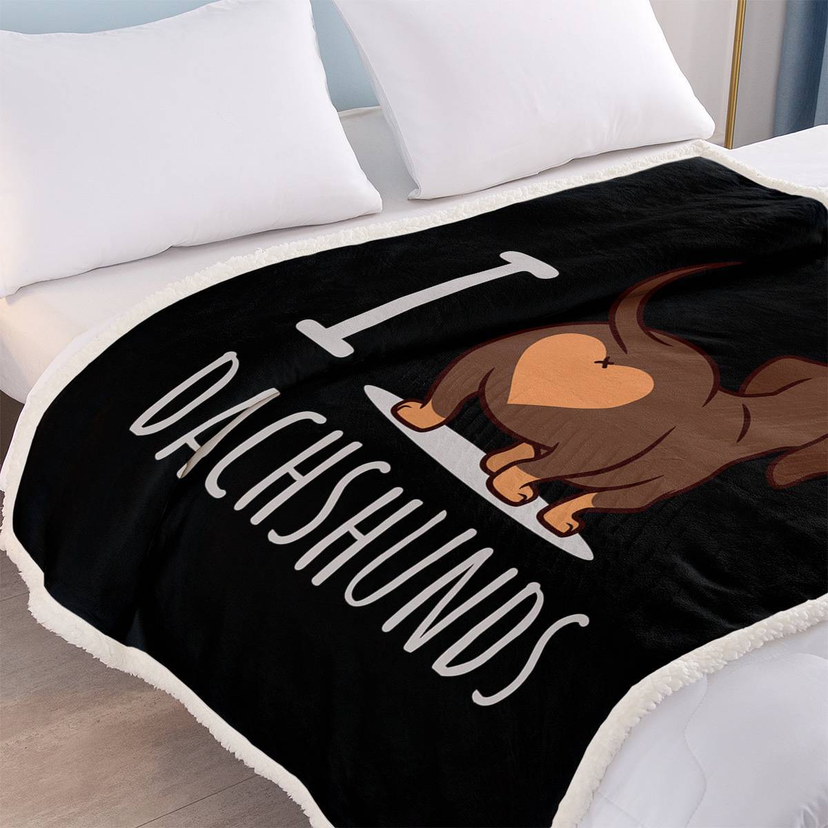 Blanket with a dachshund design and text on a bed