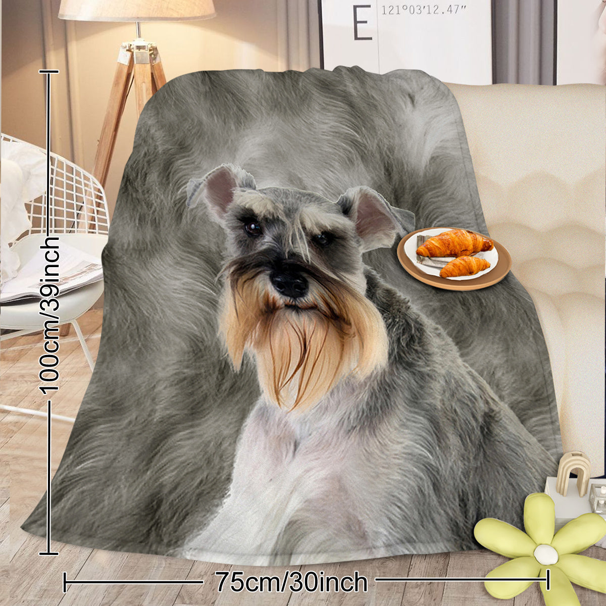 Flannel blanket with a dog design and measurements on a couch