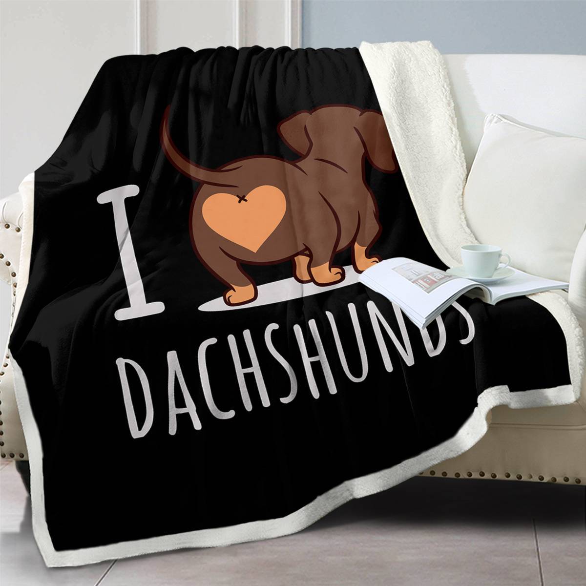 Black blanket with a dachshund design and 'I love dachshunds' text on a couch.