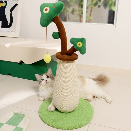 Cat playing with a green and brown cat tree toy on a light-colored floor.