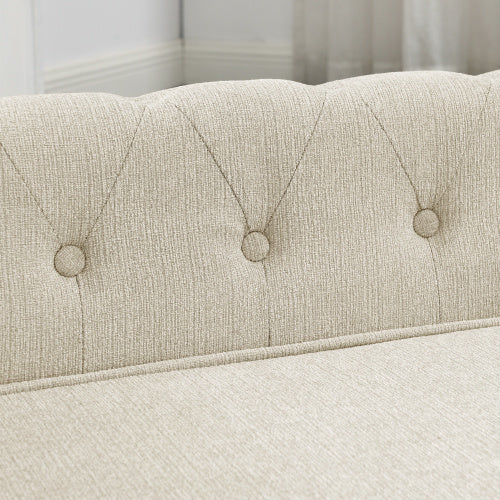 Close-up of a tufted beige upholstered headboard