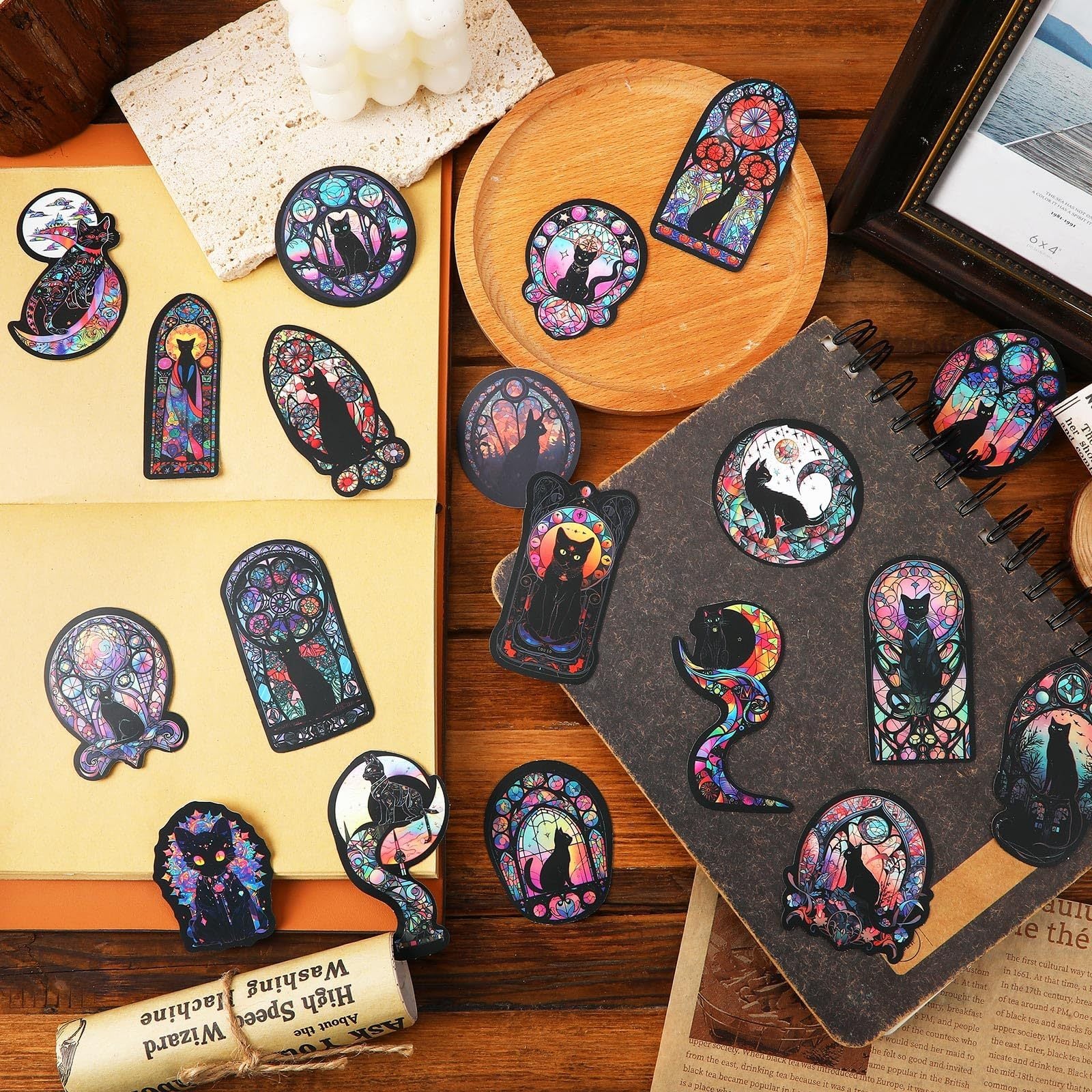Colorful cat-themed stickers on a wooden surface with a notebook.