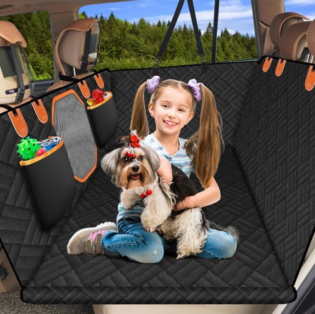 Child with a dog sitting on a car seat cover in a vehicle
